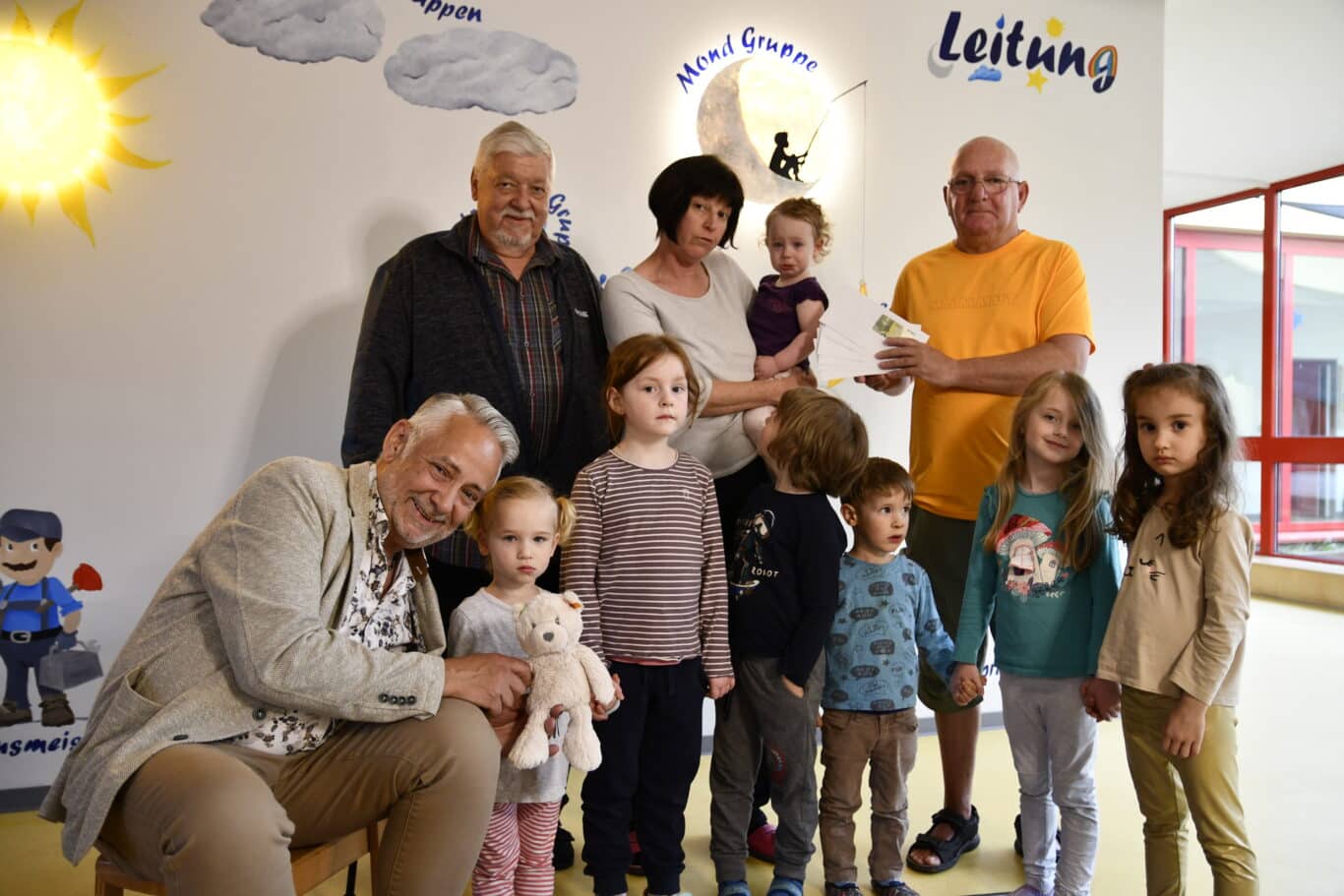 Volker Jost (rechts, orangefarbenes Shirt) mit dem 1. Beigeordneten Peter Jung (links), BGM Jung (vorne) und Kita-Leitung Fr. Woll (MItte)